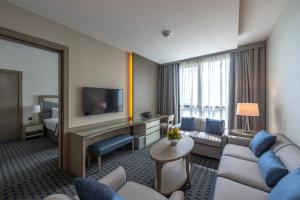 a hotel room with a couch and a television at Gulf Inn Hotel Al Nasr Formerly Roda Links Al Nasr in Dubai