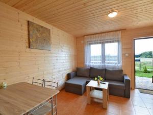 ein Wohnzimmer mit einem Sofa und einem Tisch in der Unterkunft Domki u Jagody in Sarbinowo