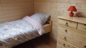 ein Schlafzimmer mit einem Bett und einem Nachttisch mit einer Lampe in der Unterkunft Domki u Jagody in Sarbinowo