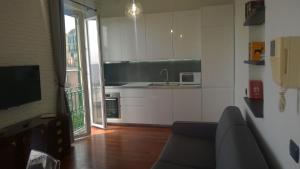 a living room with a couch and a kitchen at House Orizzonte - Casa Bianca in Genoa