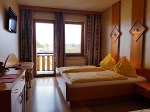 BurgauにあるGasthof Janitsのベッド2台とバルコニーが備わるホテルルームです。