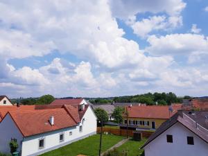 Gasthof Janits في Burgau: مجموعة من المنازل ذات السماء الغائمة في الخلفية