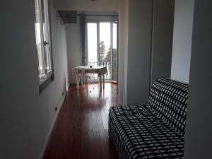 a living room with a couch and a table and a window at House Orizzonte - Casa Bianca in Genoa