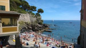 a crowd of people on a beach near the ocean at House Orizzonte - Casa Bianca in Genoa