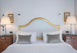a white bed with two pillows and two lamps at Hotel Casa Verardo Residenza d'Epoca in Venice