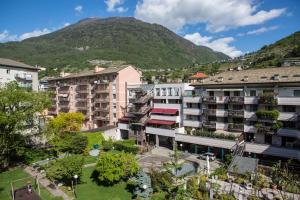 um grupo de edifícios com uma montanha ao fundo em Piazzi House em Sondrio