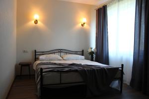 a bed in a bedroom with a window and two lights at Old Willows in Ventspils