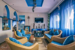 a living room with blue chairs and a table at Dar Ba Sidi & Spa Chefchaouen in Chefchaouen