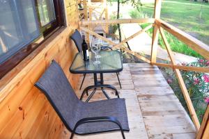 a porch with two chairs and a table with wine glasses at Saranda Beach Bungalow in Ulcinj +24 photos