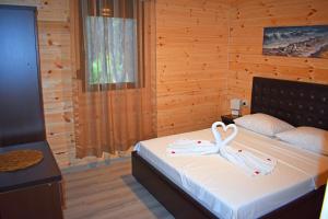 a bedroom with a bed with a ribbon on it at Saranda Beach Bungalow in Ulcinj