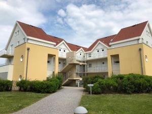 a large building with red roofs and a pathway at Les Dunes Du Golf First Line Sea View App Block B 1-3 in Wimereux