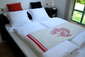 een bed met twee witte lakens met een vis erop bij De Corylus Vakantie Appartement in Oosterhesselen