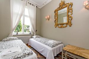 una camera da letto con due letti e uno specchio sul muro di Parkowa 1902 moj-sopot pl a Sopot