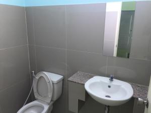 een badkamer met een wastafel, een toilet en een spiegel bij River Residence 2 in Ban Sung Yang