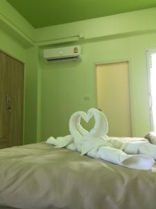 een bed met witte zwanen die een hart maken bij River Residence 2 in Ban Sung Yang