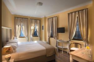 um quarto com uma cama, uma secretária e janelas em Effect Boutique Villa Azzura - Adults Only em Nesebar