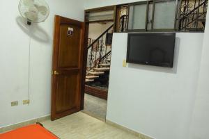 a living room with a flat screen tv on a wall at Hotel el Lago 2 in Pereira