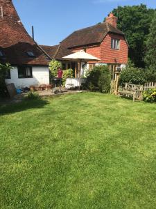 a yard in front of a house with green grass at Hurst Hill in Dunsfold