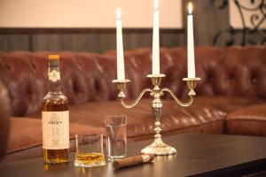 a bottle of whiskey and two glasses on a table with candles at Effect Boutique Villa Azzura - Adults Only SELF CHECK-IN in Nesebar +21 photos
