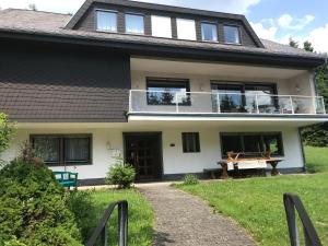 ein Haus mit einem Balkon und einem Picknicktisch in der Unterkunft Ferienhaus Beja in Winterberg