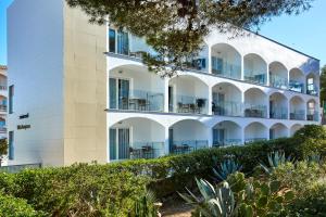 an apartment building with tables and chairs on the balconies at Universal Casa Marquesa in Colònia de Sant Jordi