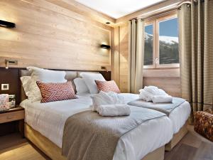 sypialnia z dużym łóżkiem z poduszkami w obiekcie Residence Anitea w mieście Valmorel
