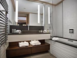 a bathroom with a sink and a mirror and towels at Residence Anitea in Valmorel
