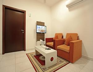 un soggiorno con due sedie, un tavolo e una porta di Star Emirates Inn a Salalah