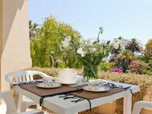 stół z talerzami i kubkami oraz wazon kwiatów w obiekcie Hotel Residence Villa Igea Capri w mieście Capri