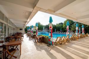 un complexe avec une piscine, des chaises et des parasols dans l'établissement Club de Vacanta Mediterraneo, à Legian