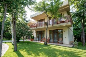 a house with a balcony and a yard at Club de Vacanta Mediterraneo in Neptun