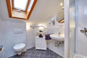 a white bathroom with a toilet and a sink at Gästehaus Anneliese in Wallgau +36 photos