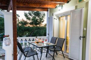 a patio with a table and chairs on a balcony at Villas Margaris in Kalamaki