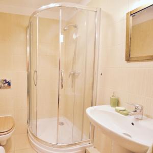 een badkamer met een douche en een wastafel bij Apartament Sosnowa 13 in Mielno