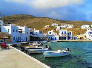 a group of boats docked in the water near buildings at Elena Studios in Panormos