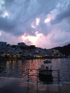 a boat in a body of water with a city at Elena Studios in Panormos