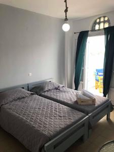 a bedroom with a large bed with a window at Elena Studios in Panormos