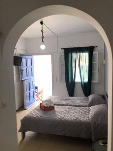 a bedroom with a large bed and a blue door at Elena Studios in Panormos