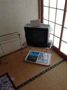 um tablet sentado no chão em frente a uma televisão em Miyasakaya em Nozawa Onsen