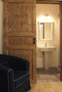 a bathroom with a wooden door and a sink at La Casetta Ferrara B&B in Ferrara