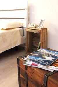 a wooden chest with magazines on it next to a bed at La Casetta Ferrara B&B in Ferrara