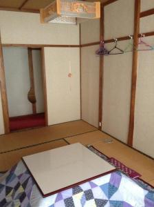 een lege kamer met een tafel en een tapijt op de vloer bij Miyasakaya in Nozawa Onsen