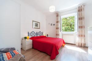 a bedroom with a red bed and a window at Vatican Stemar Apartment in Rome