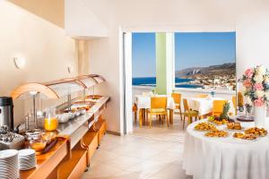 a restaurant with a buffet with a view of the ocean at Kythea Resort in Agia Pelagia