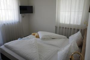 シランドロにあるPension Pernthalerのベッドルーム1室(白いシーツ付きのベッド2台、テレビ付)