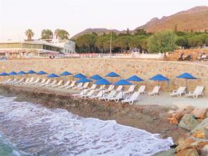 un grupo de sillas y sombrillas azules en una playa en Sunset Mavi, en Turgutreis