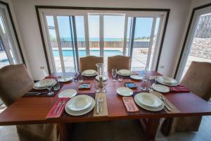 a wooden table with plates and glasses on top of it at Turtles Nest Villa in Treasure Beach
