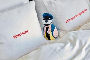 
a stuffed animal on a bed with pillows at 25hours Hotel Das Tour in Düsseldorf
