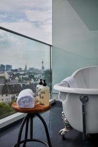
a bath tub sitting next to a window in a bathroom at 25hours Hotel Das Tour in Düsseldorf
