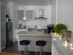 a kitchen with two bar stools and a counter top at Les chanceliers Duplex in Beaune